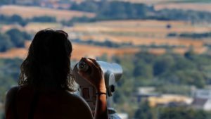 woman looking through view finder over landscape